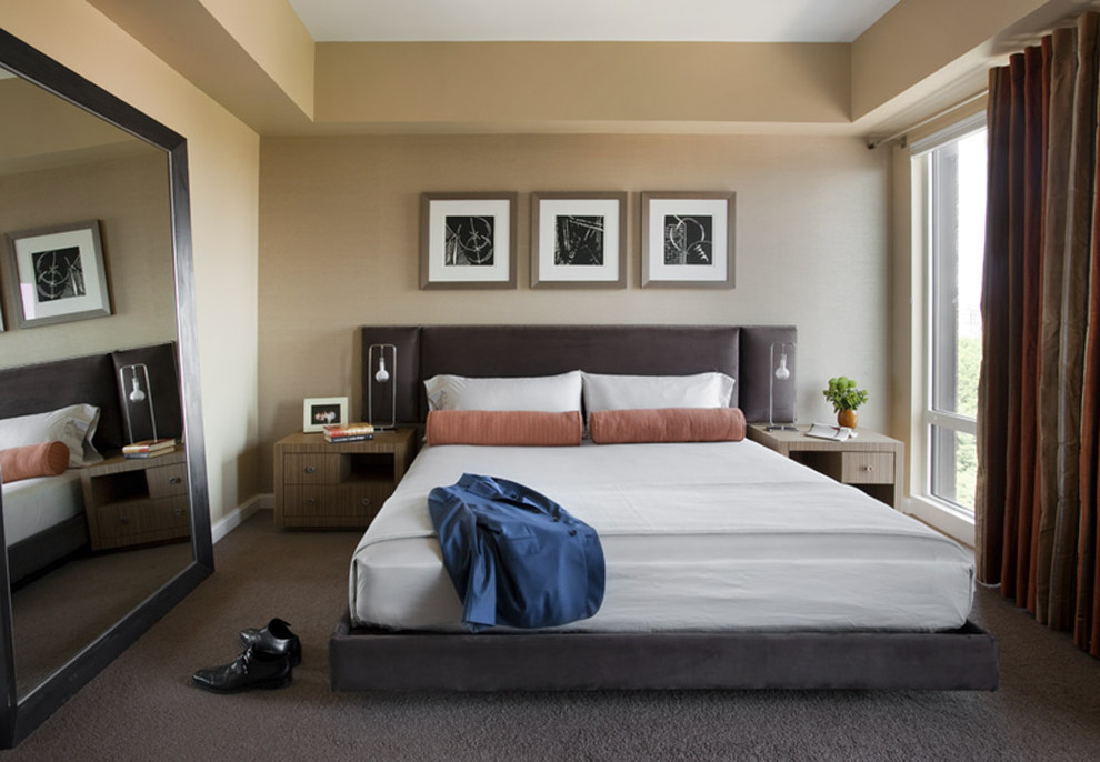 Immagine di una camera da letto design con pareti beige, moquette e nessun camino