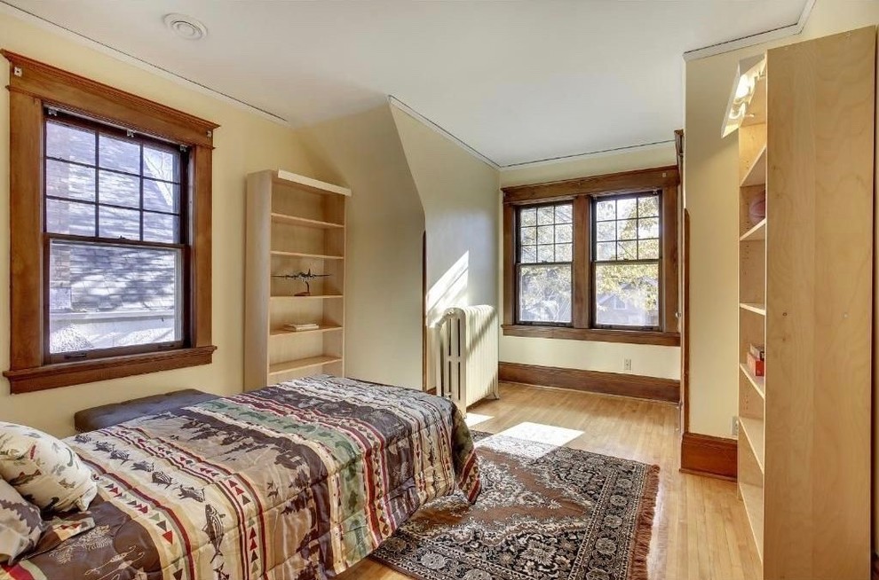 Mittelgroßes Uriges Hauptschlafzimmer ohne Kamin mit beiger Wandfarbe, hellem Holzboden und beigem Boden in Minneapolis