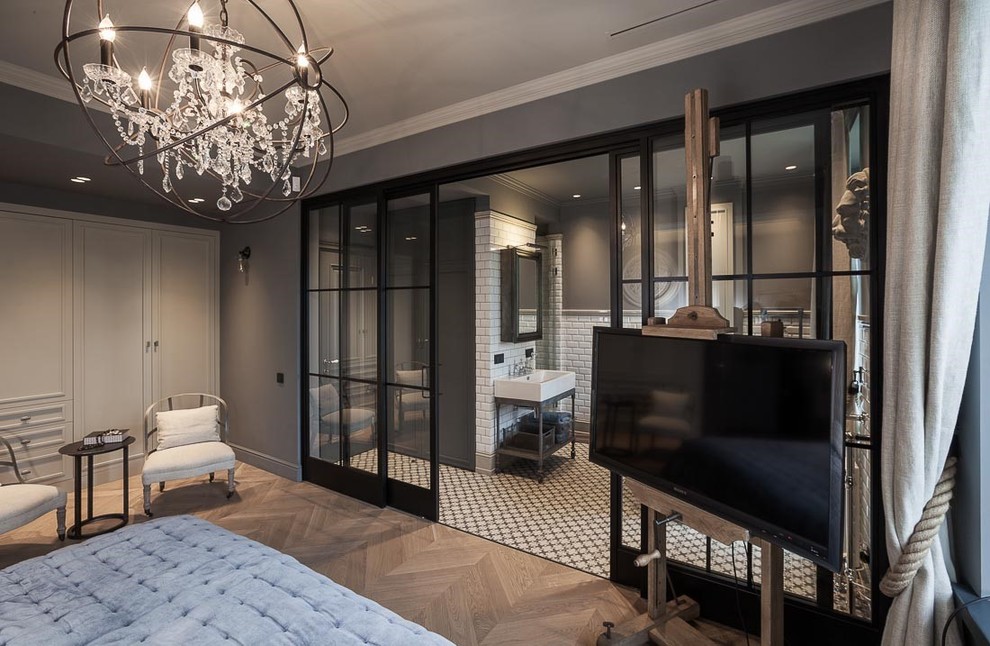 Photo of a large urban master bedroom in London with grey walls and medium hardwood flooring.