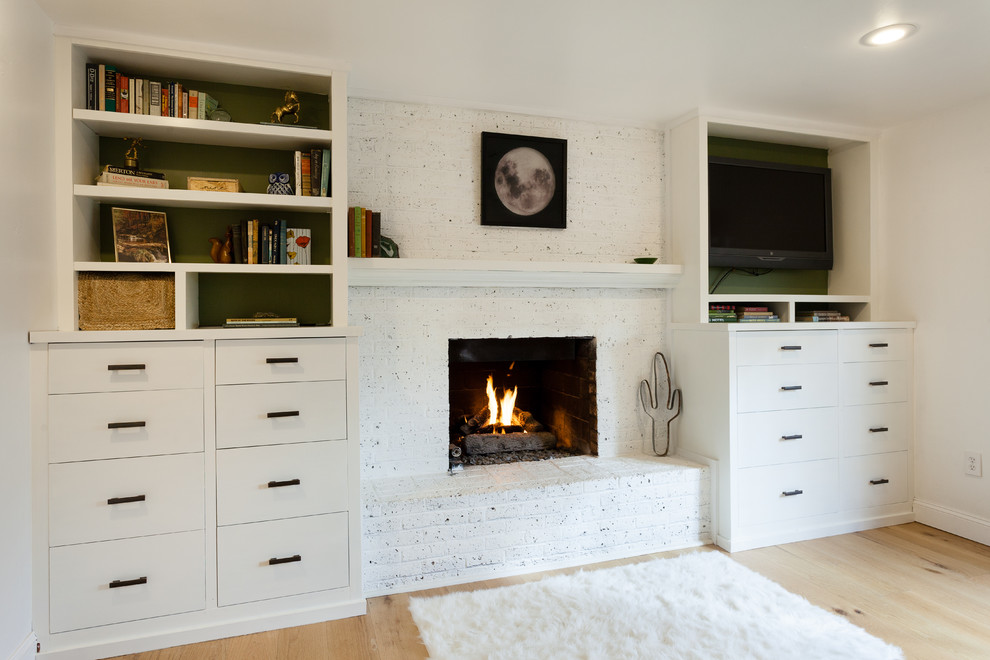 Aménagement d'une chambre parentale éclectique de taille moyenne avec un mur blanc, parquet clair, une cheminée standard et un manteau de cheminée en brique.
