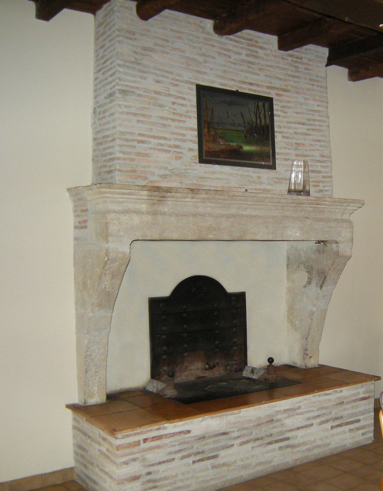 Cette photo montre une chambre parentale méditerranéenne avec un manteau de cheminée en pierre.
