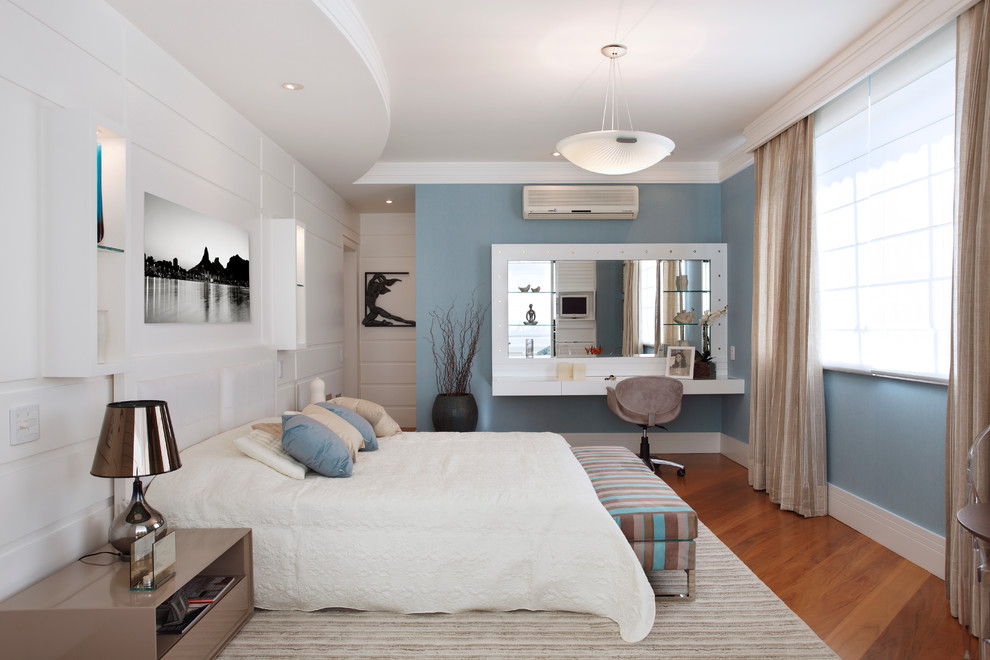 Imagen de dormitorio actual con paredes azules y suelo de madera en tonos medios