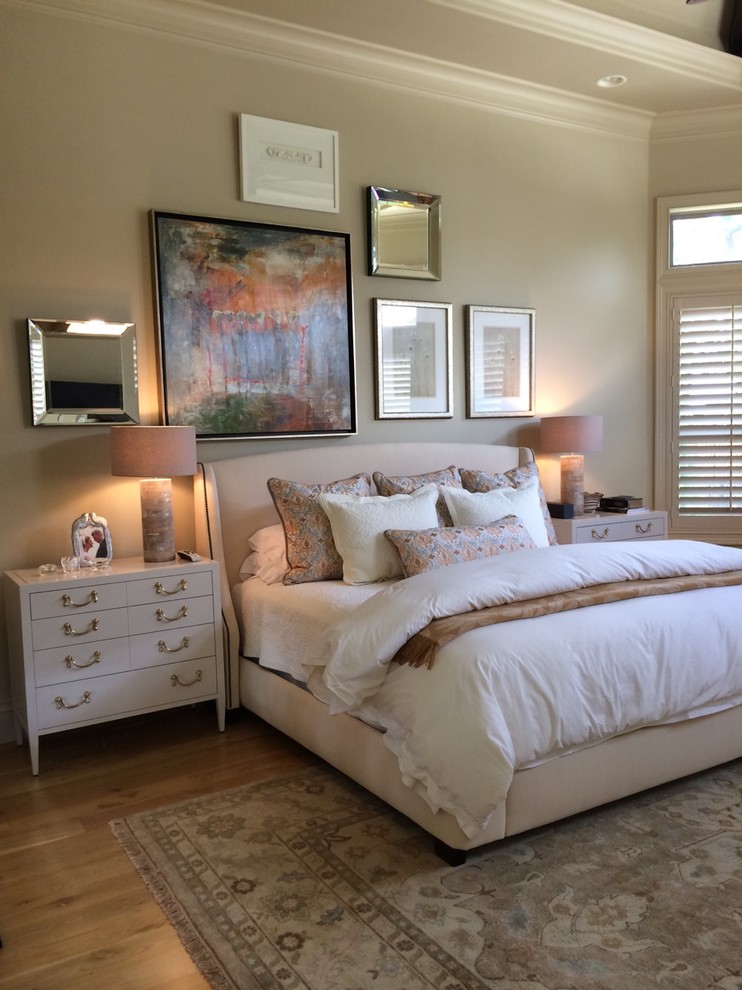 Modelo de dormitorio principal tradicional renovado grande con paredes beige y suelo de madera clara
