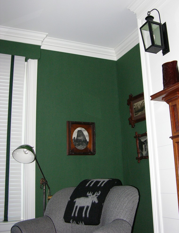 オースティンにある中くらいなラスティックスタイルのおしゃれな客用寝室 (緑の壁、無垢フローリング、標準型暖炉、木材の暖炉まわり)