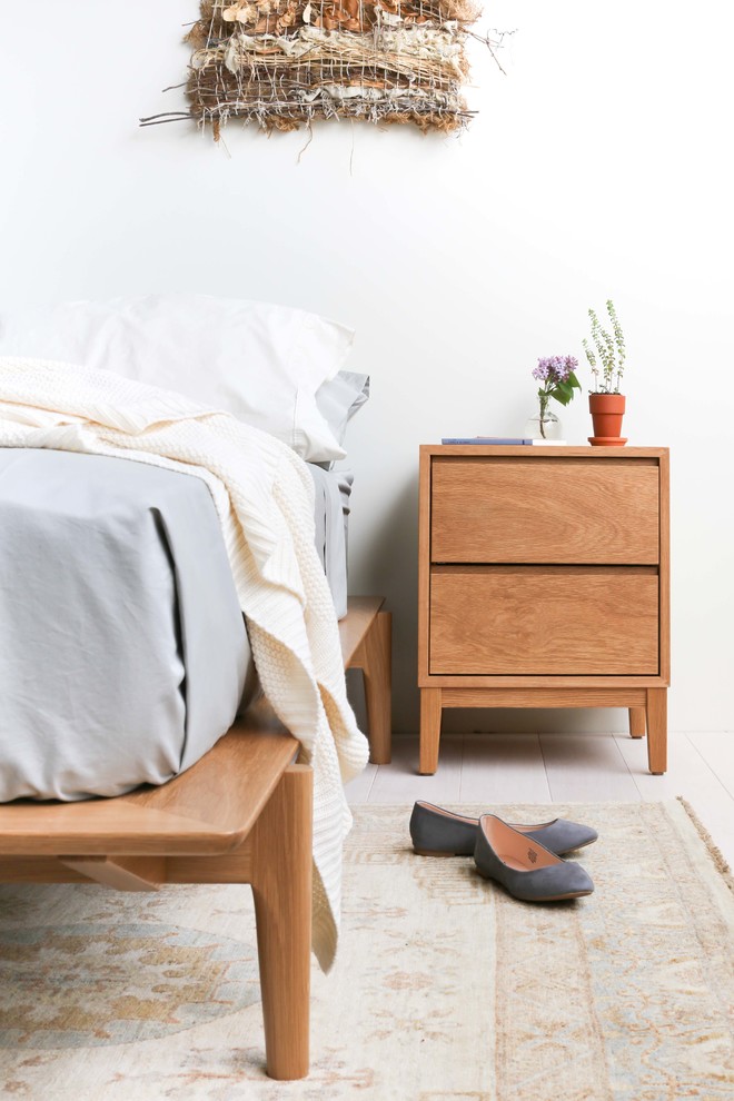 На фото: хозяйская спальня среднего размера в стиле фьюжн с белыми стенами и деревянным полом с