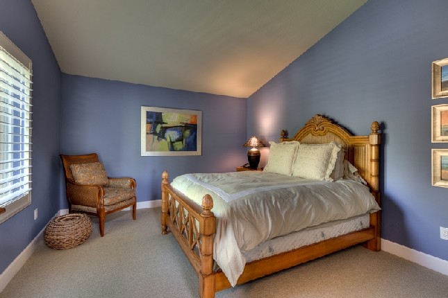 Cette photo montre une chambre chic de taille moyenne avec un mur bleu et un sol beige.