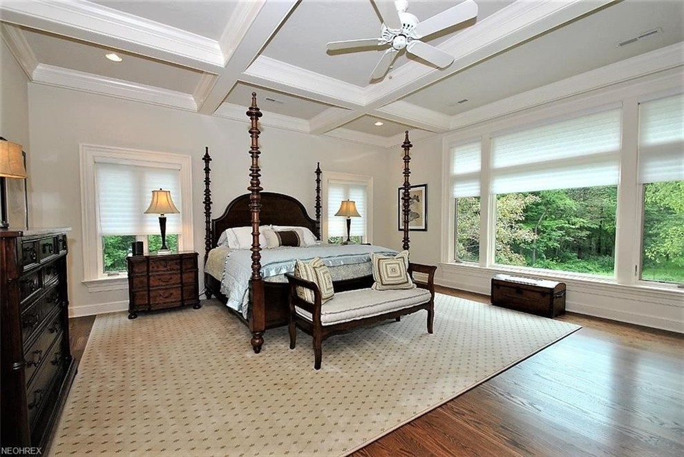 Diseño de dormitorio principal clásico grande sin chimenea con paredes grises y suelo de madera en tonos medios