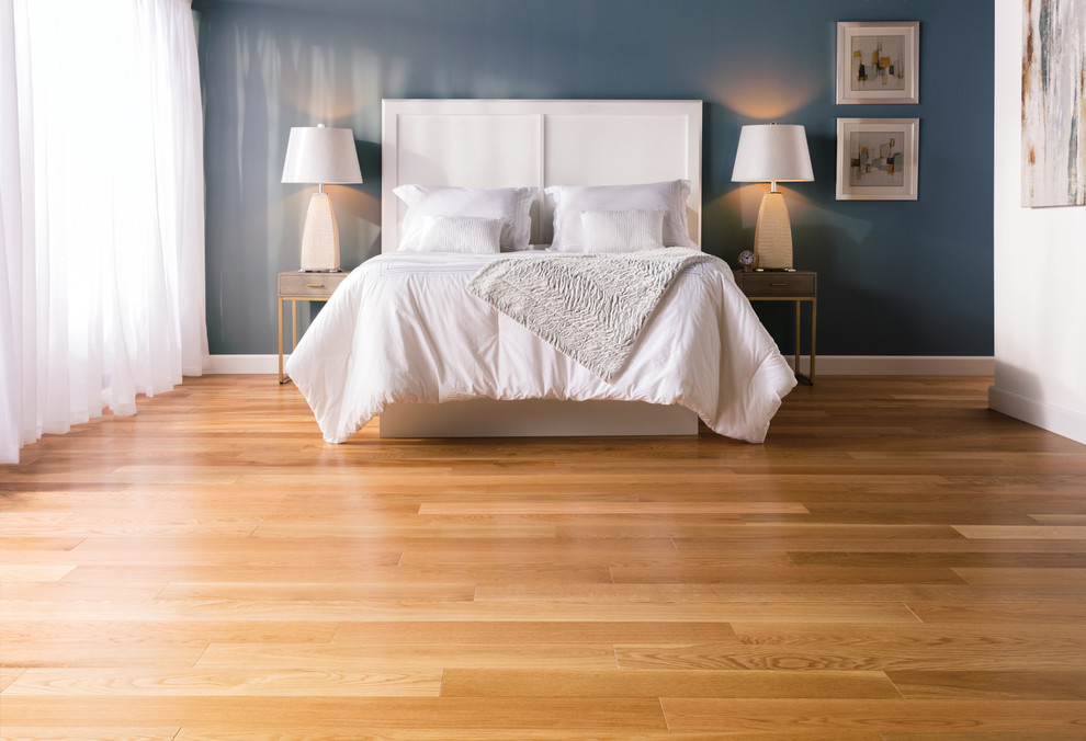 Diseño de habitación de invitados minimalista de tamaño medio sin chimenea con paredes azules y suelo de madera clara