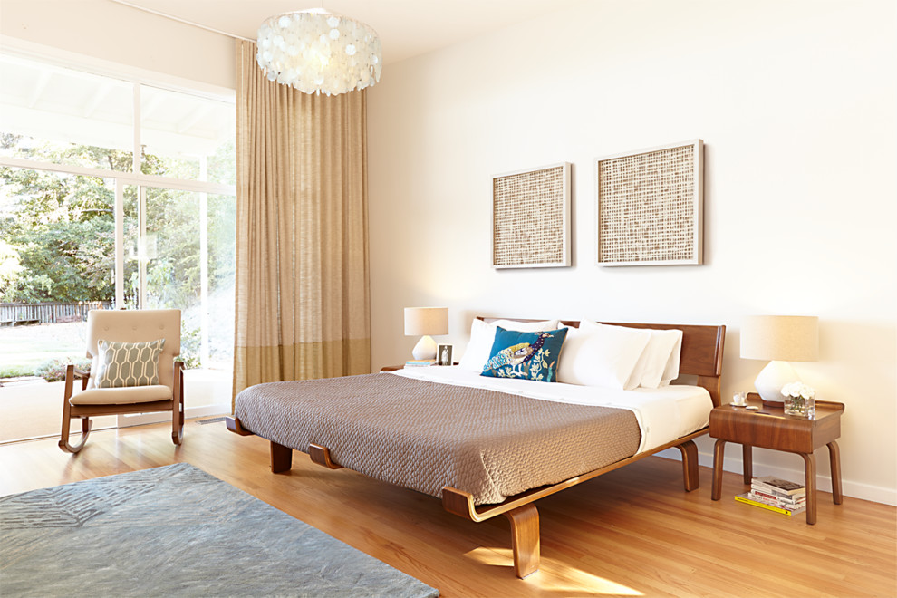 Esempio di una camera da letto design con pareti beige e pavimento in legno massello medio