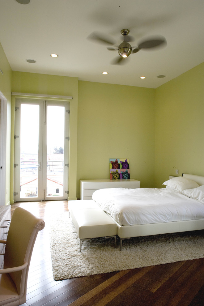 Réalisation d'une chambre minimaliste avec un mur vert et parquet foncé.