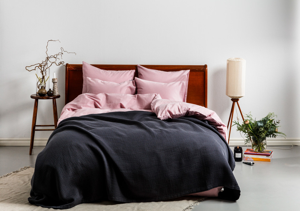 На фото: спальня в скандинавском стиле с серыми стенами, бетонным полом и серым полом с