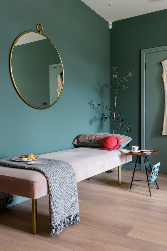 Scandi bedroom in London with green walls, light hardwood flooring and beige floors.
