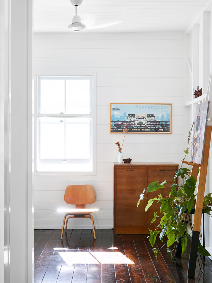 Immagine di una camera degli ospiti minimalista di medie dimensioni con pareti bianche, parquet scuro e pavimento nero