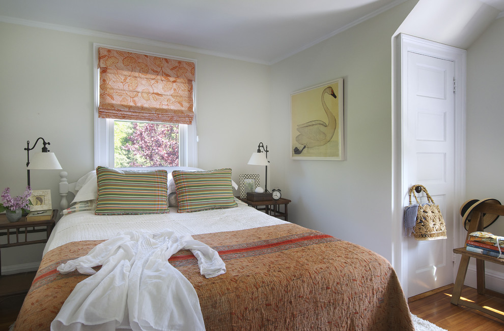 Example of a beach style medium tone wood floor bedroom design in Providence with beige walls