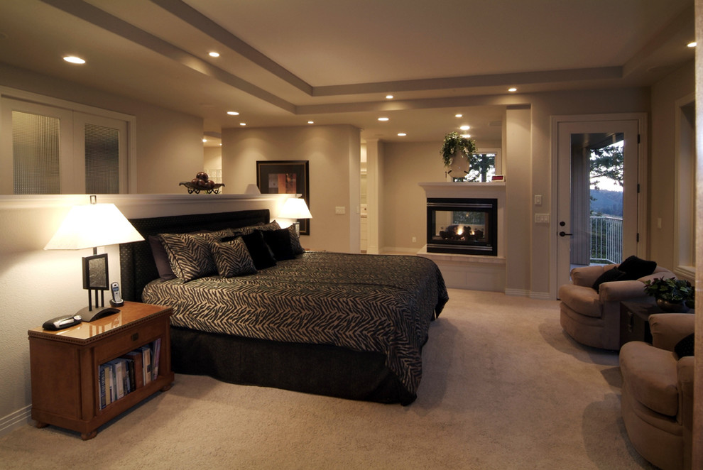 Пример оригинального дизайна: спальня в классическом стиле с серыми стенами, ковровым покрытием и двусторонним камином