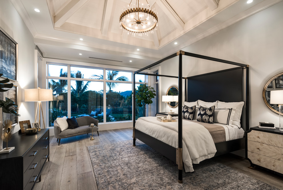Imagen de dormitorio principal contemporáneo con paredes grises, suelo de madera en tonos medios y suelo gris