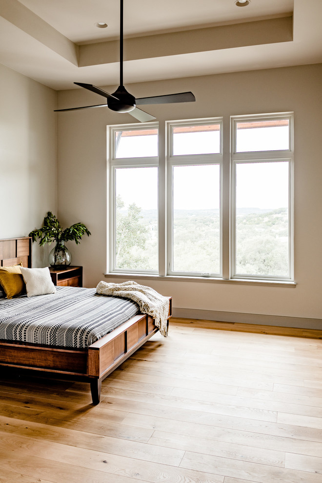 Modernes Schlafzimmer mit hellem Holzboden in Austin