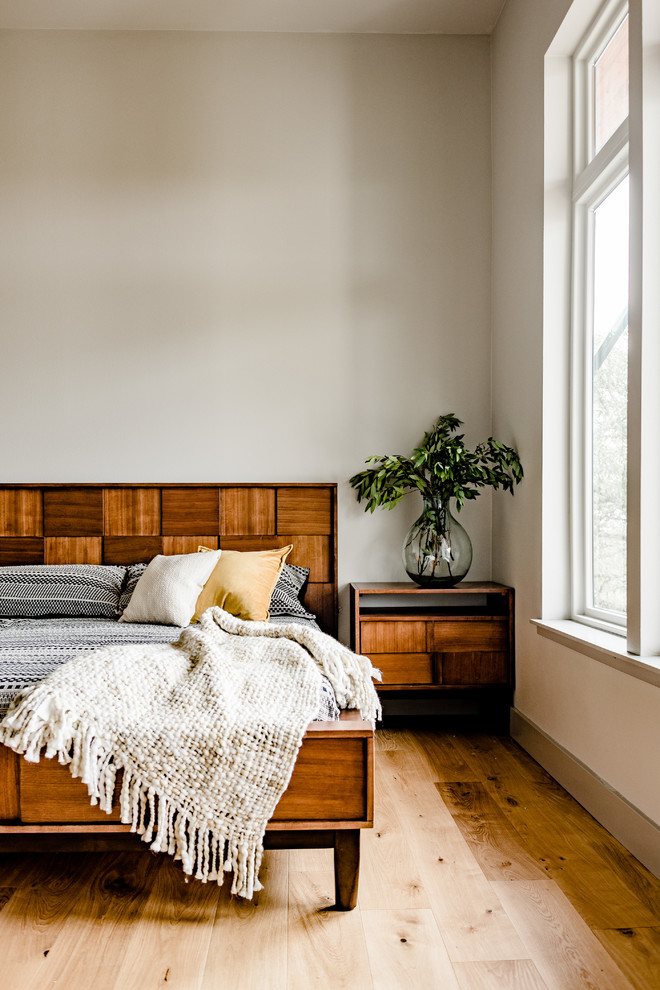 Modernes Schlafzimmer mit beiger Wandfarbe und hellem Holzboden in Austin