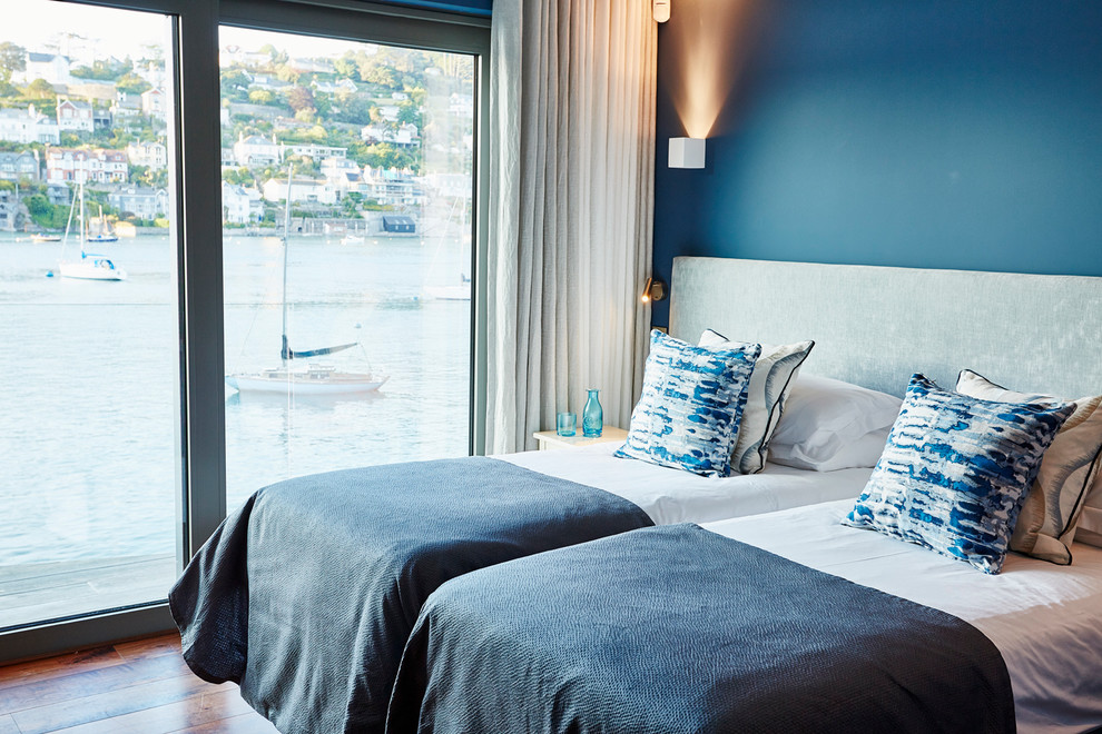 ウエストミッドランズにある中くらいなコンテンポラリースタイルのおしゃれな客用寝室 (青い壁、濃色無垢フローリング) のインテリア
