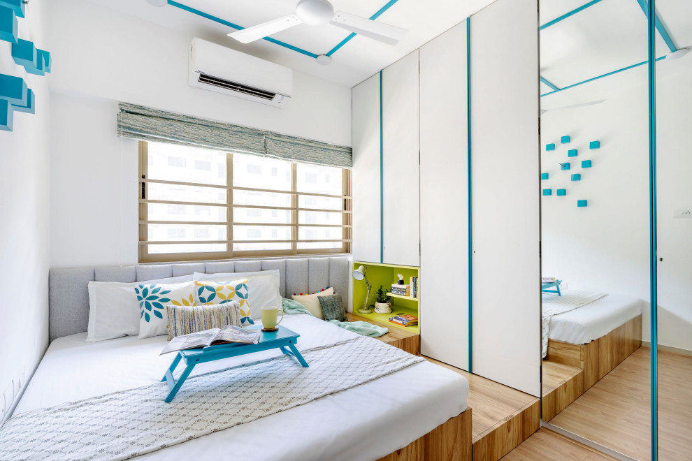 Foto di una camera da letto contemporanea con pareti bianche, parquet chiaro e pavimento beige