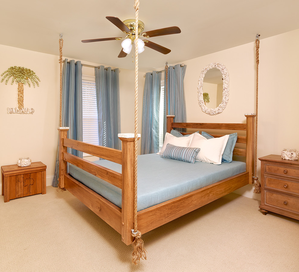 チャールストンにあるビーチスタイルのおしゃれな寝室 (ベージュの壁、カーペット敷き、青いカーテン) のレイアウト