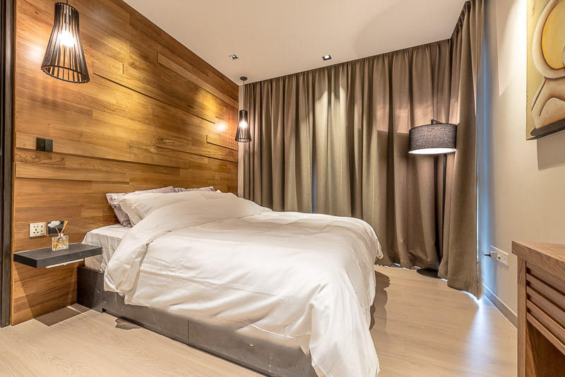 Kleines Uriges Hauptschlafzimmer mit brauner Wandfarbe und hellem Holzboden in Singapur