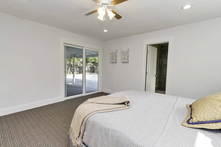 Example of a mid-sized trendy master carpeted bedroom design in Orange County with white walls and no fireplace