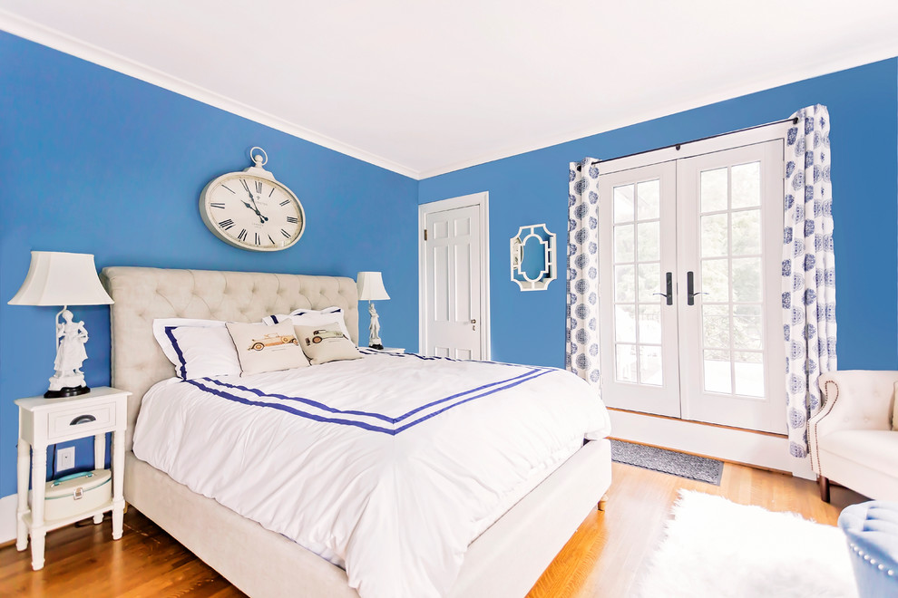 Modelo de habitación de invitados tradicional con paredes azules y suelo de madera en tonos medios