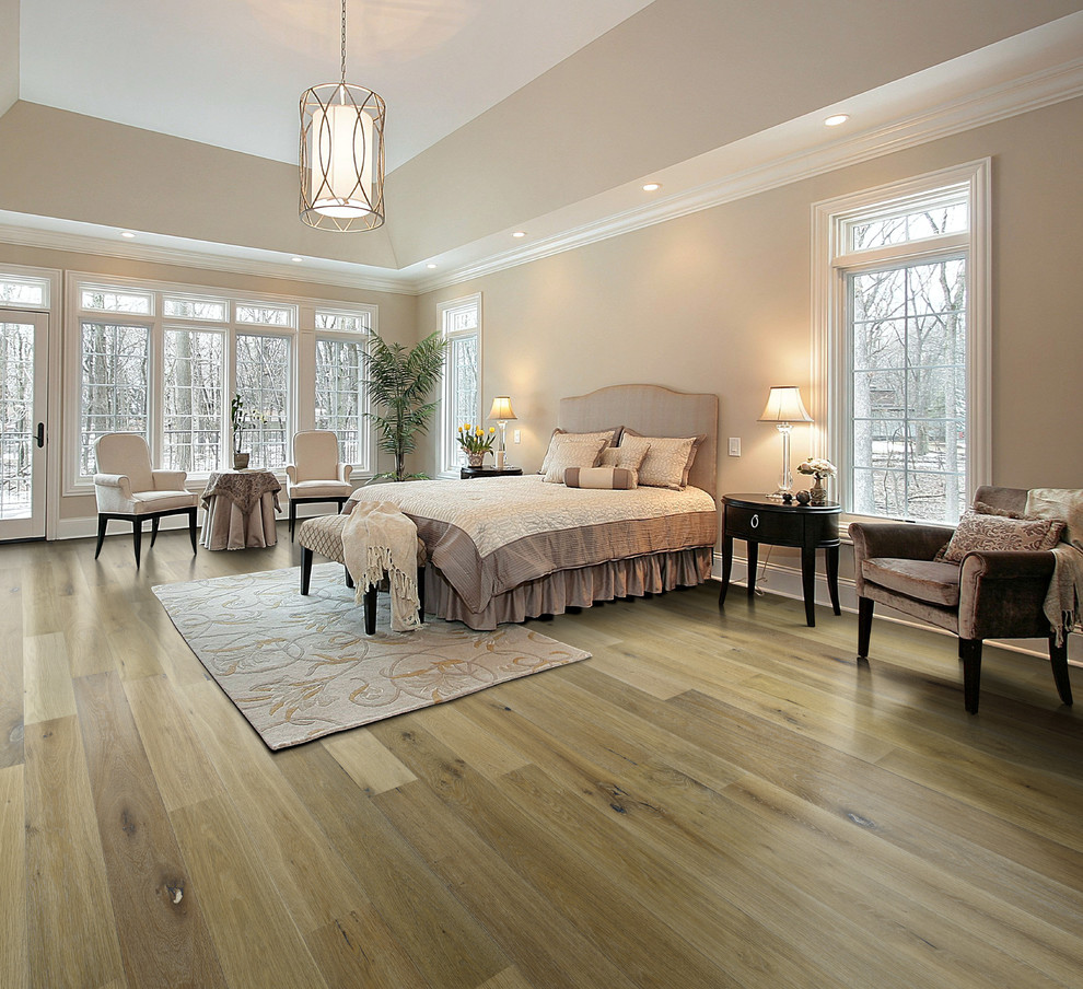 Example of a classic master light wood floor bedroom design in Los Angeles with beige walls