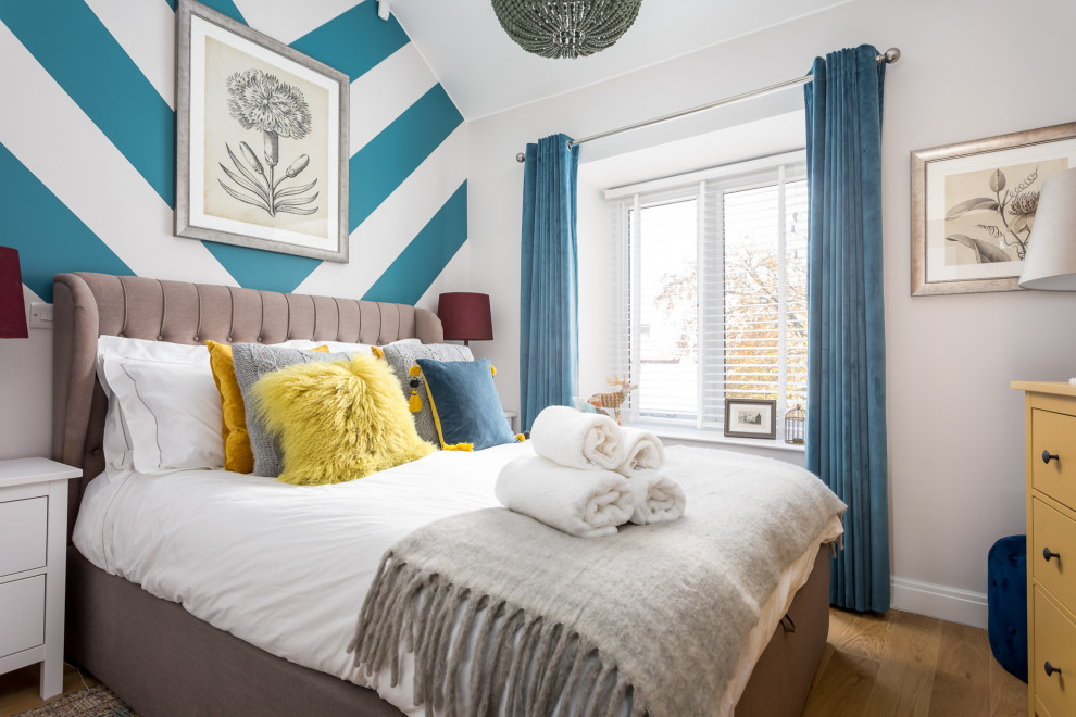 На фото: гостевая спальня среднего размера, (комната для гостей) в стиле фьюжн с разноцветными стенами, коричневым полом, паркетным полом среднего тона, сводчатым потолком, обоями на стенах и синими шторами