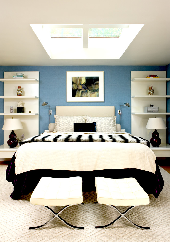 Diseño de dormitorio principal moderno de tamaño medio sin chimenea con paredes azules, suelo de madera en tonos medios y suelo marrón
