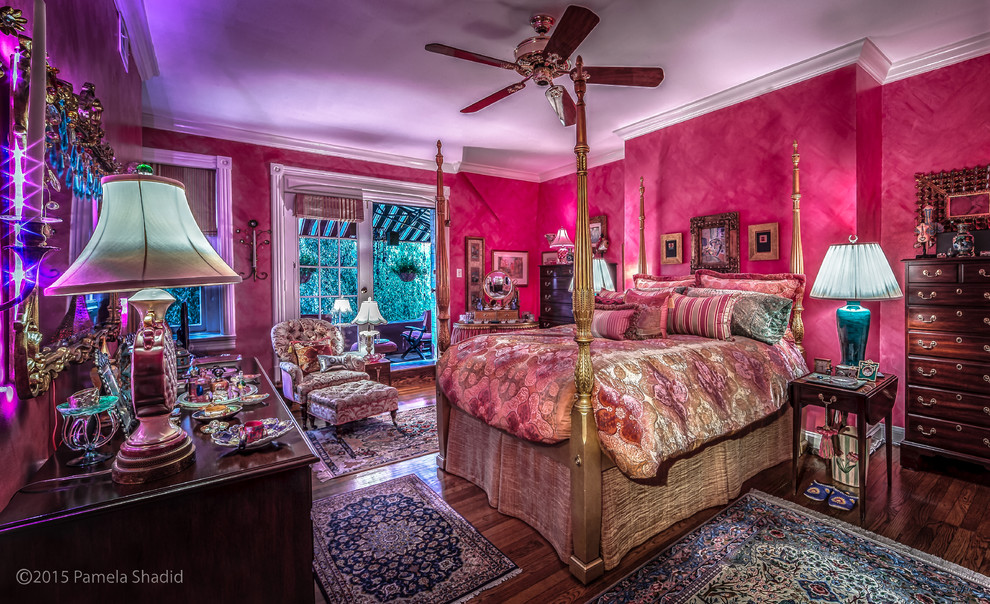 Ispirazione per un'ampia camera matrimoniale boho chic con pareti rosa e pavimento in legno massello medio