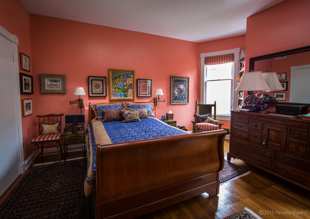 Foto de habitación de invitados bohemia grande con parades naranjas y suelo de madera en tonos medios
