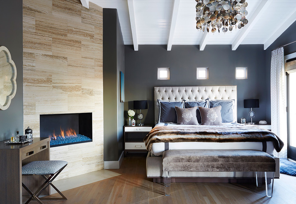 Mid-sized trendy master medium tone wood floor bedroom photo in Los Angeles with gray walls, a ribbon fireplace and a tile fireplace
