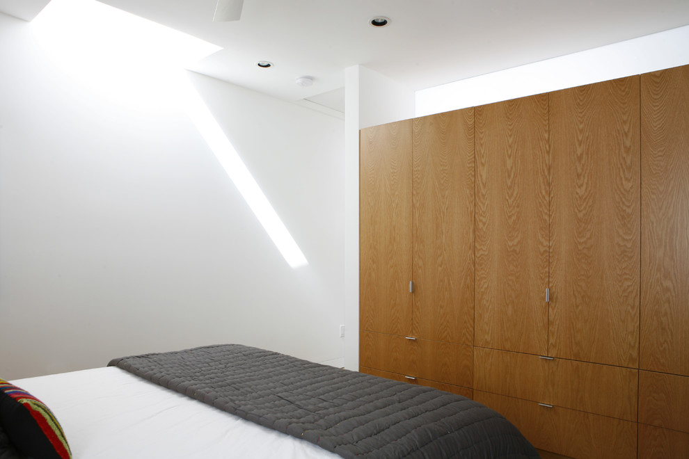 Imagen de dormitorio moderno pequeño con paredes blancas