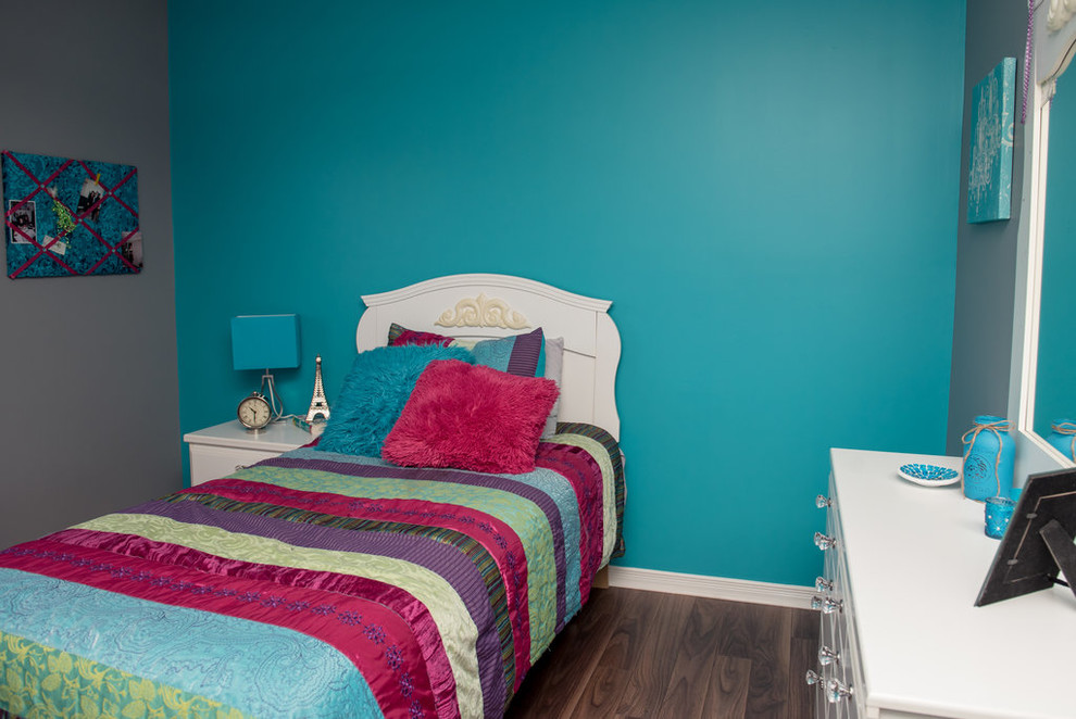 Modelo de dormitorio ecléctico pequeño con paredes azules, suelo laminado y suelo marrón