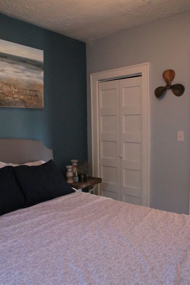 Réalisation d'une petite chambre d'amis marine avec un mur bleu et parquet clair.