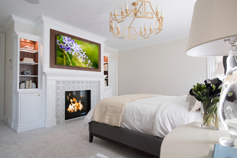 Photo of a large classic master bedroom in Cleveland with beige walls, carpet, a standard fireplace, a tiled fireplace surround and grey floors.