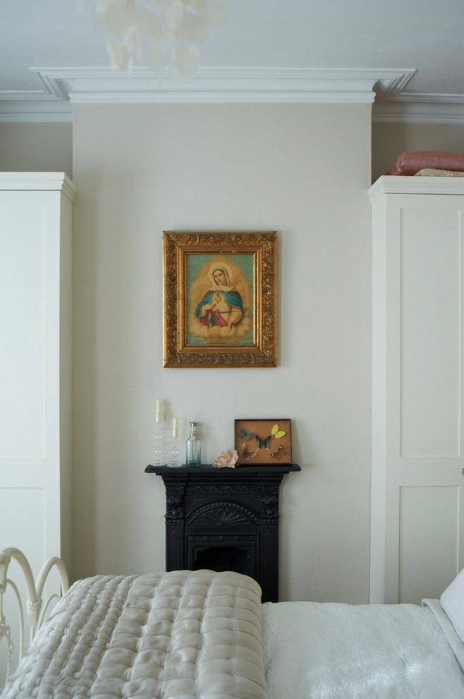 ロンドンにある中くらいなエクレクティックスタイルのおしゃれな主寝室 (ベージュの壁、標準型暖炉、金属の暖炉まわり) のレイアウト