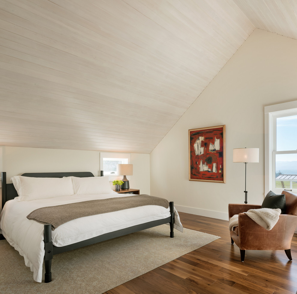 Großes Country Hauptschlafzimmer mit beiger Wandfarbe, braunem Holzboden, Kamin, Kaminumrandung aus Stein und braunem Boden in Sonstige