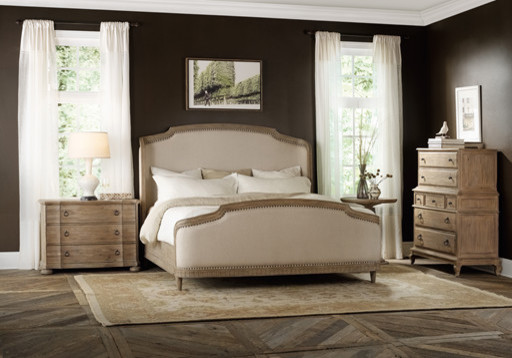 На фото: большая хозяйская спальня в классическом стиле с коричневыми стенами и темным паркетным полом с