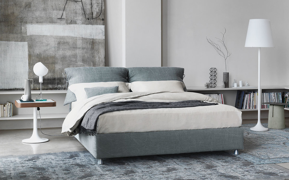 Modelo de dormitorio tipo loft minimalista de tamaño medio sin chimenea con paredes grises y suelo de cemento