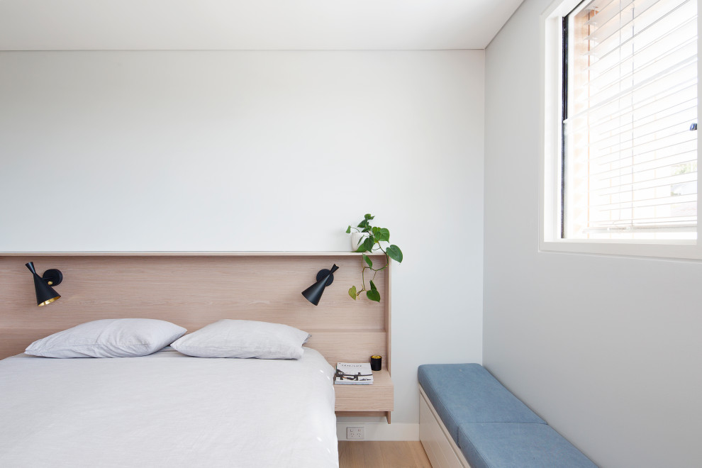 Foto på ett maritimt sovrum, med vita väggar, ljust trägolv och beiget golv