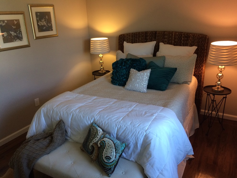 Immagine di una piccola camera degli ospiti classica con pareti beige, pavimento in legno massello medio e nessun camino