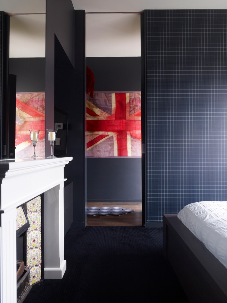 Пример оригинального дизайна: спальня в современном стиле с черными стенами, стандартным камином и черным полом