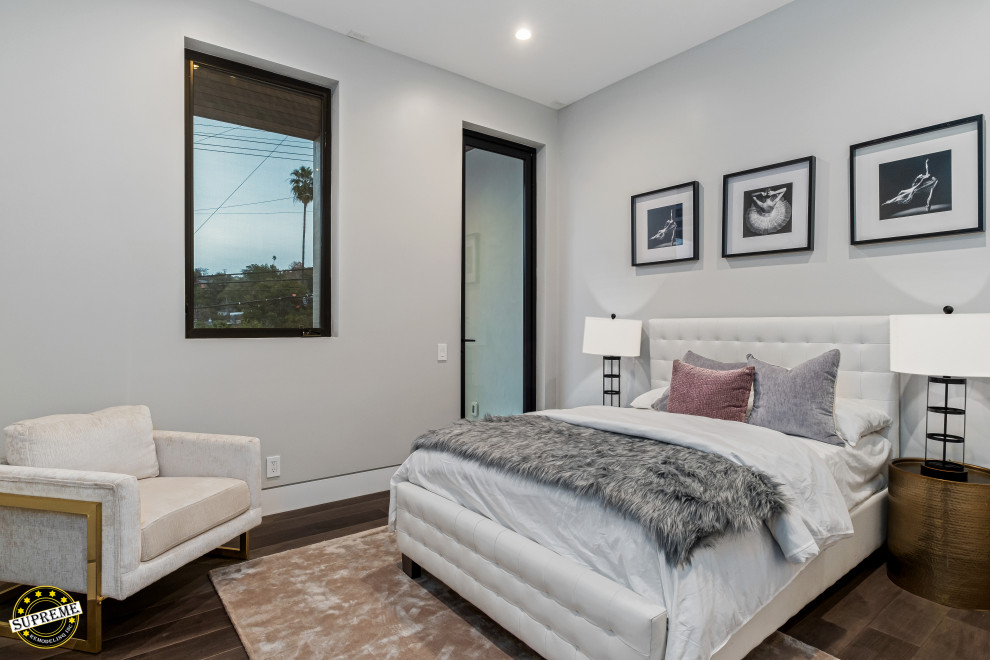 Imagen de habitación de invitados minimalista de tamaño medio con paredes blancas, suelo de madera oscura y suelo marrón