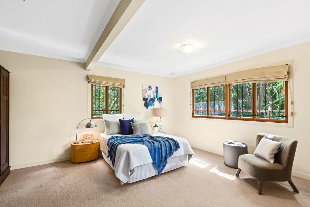 This is an example of a contemporary guest bedroom in Brisbane with beige walls, light hardwood flooring and brown floors.