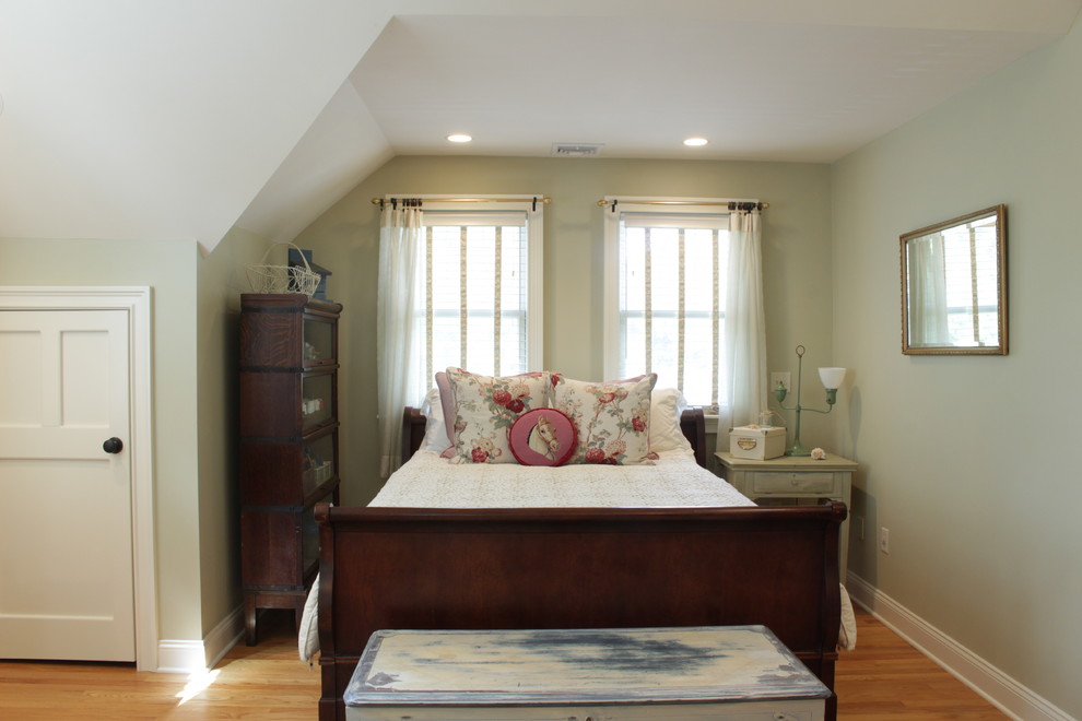 Foto de habitación de invitados campestre grande sin chimenea con paredes verdes, suelo de madera en tonos medios y suelo marrón