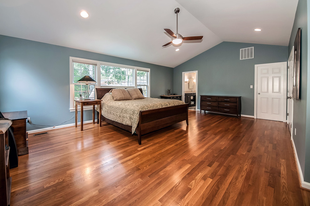 Foto de dormitorio principal actual grande con paredes azules y suelo de madera en tonos medios