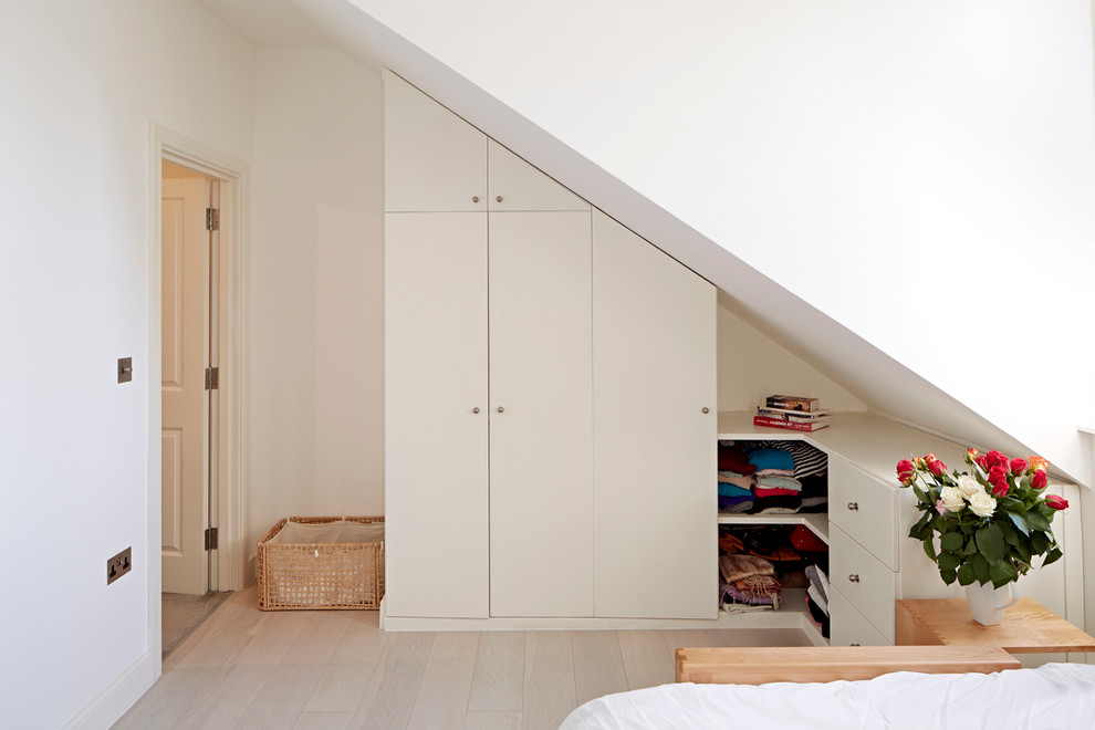 Inspiration for a medium sized contemporary bedroom in London with light hardwood flooring.